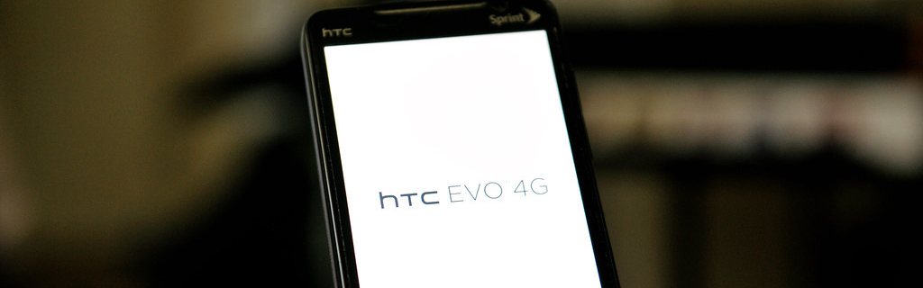 An HTC Evo 4G held up with the screen lit.