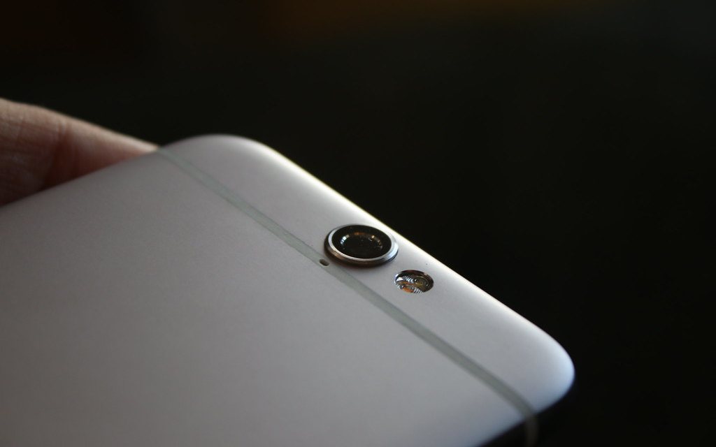 The rear camera housing of an HTC One A9, held in one hand.