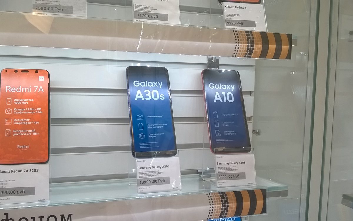 Handsets on a shop display, each with its own price card.